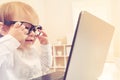 Smart toddler girl wearing big glasses using her laptop Royalty Free Stock Photo