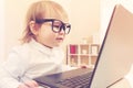 Smart toddler girl wearing big glasses using her laptop Royalty Free Stock Photo