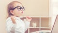 Smart toddler girl wearing big glasses using her laptop Royalty Free Stock Photo