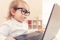 Smart toddler girl wearing big glasses using her laptop Royalty Free Stock Photo