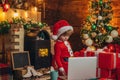 Smart toddler surfing internet. Santa little helper. Little boy santa hat and costume. Boy child with laptop near