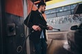 Smart trendy man in jeans and blaser is washing his own car at car washing station Royalty Free Stock Photo