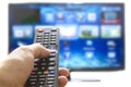 Smart tv and hand pressing remote control Royalty Free Stock Photo