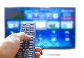 Smart tv and hand pressing remote control Royalty Free Stock Photo