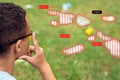 Smart Waste Sorting. African boy wearing digital glasses sitting in the park looking at grass pensive using app for