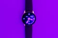 Smart watch on the glowing neon purple,veri peri color background with empty space for your text.Closeup,copy space Royalty Free Stock Photo