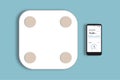 Smart weight scale and a smartphone with a with an app graphic on the mobile screen. Smart body analyzer