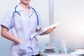 Smart woman doctor stand and holding patient chart with blue ste Royalty Free Stock Photo