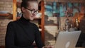 Smart woman in glasses working at home on laptop in home office Royalty Free Stock Photo