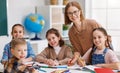 Teacher helping children with schoolwork at school Royalty Free Stock Photo