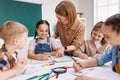 Teacher helping children with schoolwork Royalty Free Stock Photo