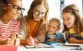 friendly teacher helping happy children with schoolwork Royalty Free Stock Photo