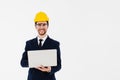 Smart young architect wearing glasses and yellow safety helmet which hands holding a laptop to check his planned work. Royalty Free Stock Photo