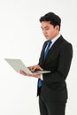 A smart young asian businessman or entrepreneur wearing formal black suit standing over white background, holding and looking at Royalty Free Stock Photo