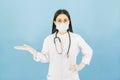 Smart young asian female doctor in lab coat with Medical face mask,white latex medical gloves and stethoscope against blue Royalty Free Stock Photo