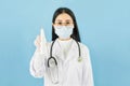 Smart young asian female doctor in lab coat with Medical face mask,white latex medical gloves and stethoscope,Holding a bottle of Royalty Free Stock Photo