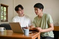 A smart young Asian male college student is tutoring and helping his friend with math at home Royalty Free Stock Photo