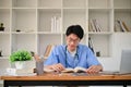 Smart young Asian male medical student in a uniform focuses on reading a book Royalty Free Stock Photo