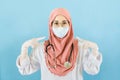 Smart young asian muslim woman doctor in lab coat with Medical face mask,white latex medical gloves and stethoscope, make gesture Royalty Free Stock Photo