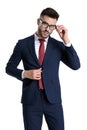 Smart young businessman adjusting his glasses and jacket Royalty Free Stock Photo