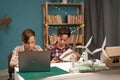 Smart young children's work as a team using laptop computer making school project with wind turbines. Two friends Royalty Free Stock Photo