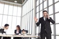 Smart young handsome businessman with black hair in suit talking on mobile phone while confident sitting on office working desk at Royalty Free Stock Photo