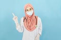 Smart young muslim woman doctor in lab coat with Medical face mask,white latex medical gloves and stethoscope against blue Royalty Free Stock Photo