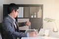 Smart youngadult 40s asian man with eye glasses working on laptop or computer notebook in modern working space. office life and