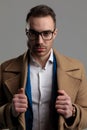 Smartcasual fashion model wearing glasses and fixing coat