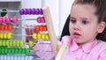 Smartest little girl in the office conducts raschty using colored wooden abacus