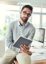 Only the smartest work with the most efficient tools. Portrait of a handsome young businessman using a digital tablet in