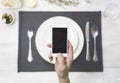 Smartphone above diner setting Royalty Free Stock Photo