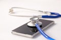 Smartphone being diagnosed by stethoscope - phone repair and check up concept. Royalty Free Stock Photo