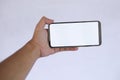 Hand Holding Smartphone with Blank White Screen on light Background Royalty Free Stock Photo