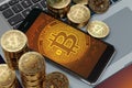 Smartphone with Bitcoin symbol on-screen laying on computer keyboard