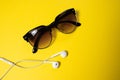 Smartphone with Blank Screen Connects to Earphones with Spiral Cable on yellow Background Top View, Sunglasses