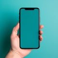 Smartphone with blank screen in female hand on turquoise background Royalty Free Stock Photo