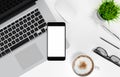 Smartphone with blank screen, laptop, coffee cup, glasses, pen and pencil on white office desk table, top view, workspace design, Royalty Free Stock Photo