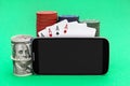 Smartphone with blank screen, poker chips, playing cards and money on green background. Online casino. Space for text Royalty Free Stock Photo