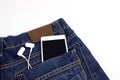 Smartphone with blank screen and white headphone sticking out of the back pocket jeans. Music concept Royalty Free Stock Photo