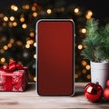 Smartphone with blank screen on wooden table and christmas tree in background Royalty Free Stock Photo