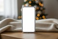 Smartphone with blank screen on wooden table in a festive setting Royalty Free Stock Photo