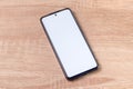 A smartphone with blank white screen on the wooden table Royalty Free Stock Photo