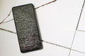 Smartphone with broken screen on cracked floor Royalty Free Stock Photo