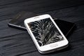 Smartphone with broken screen on dark background. Close-up Royalty Free Stock Photo