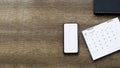 Smartphone,calender on old woodle background top view mockup screen Royalty Free Stock Photo