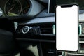 Smartphone in a car use for Navigate or GPS. Driving a car with Smartphone in holder. Mobile phone with isolated white screen. Royalty Free Stock Photo