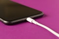 Smartphone on charge . On a purple background. Close up Royalty Free Stock Photo