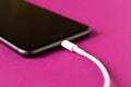 Smartphone on charge . On a purple background. Close up Royalty Free Stock Photo