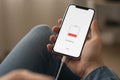 Smartphone charging at 10% battery, held in hand with cable connected, screen showing low power and charging status. Royalty Free Stock Photo